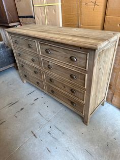 a large wooden dresser sitting in a room with boxes on the floor and cardboard behind it