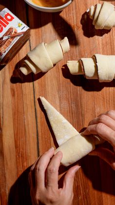 someone is making some food on a wooden table and it looks like they have been cut into pieces