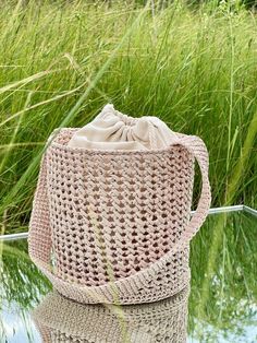 Raffia Bucket Bag, Handcrafted Basket  Bag, Raffia Drawstring Bag, Quality Raffia Bag, Crochet Raffia Bucket Bag --------------------------------- Introducing the Raffia Bucket Handbag, a fusion of traditional craftsmanship and contemporary elegance. Hand crocheted delicately from natural Raffia, this bag embodies sophistication in every stitch. (Raffia is a fibre derived from the leaves of a palm tree). Inspired by the rustic charm of traditional baskets, the Bucket Bag seamlessly blends practicality with style. Thanks to the handle on the shoulder, it is comfortably worn, while the reinforced bottom provides stability and durability. Inside the bag, there is a cotton lining to keep your belongings secure. With a simple yet elegant shape, the Handbag effortlessly complements a variety of Raffia Bucket Bag, Traditional Baskets, Bucket Handbags, Raffia Bag, Basket Bag, Bag Crochet, Daffodils, Hand Crochet, Rustic Charm