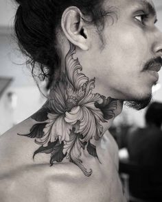 a man with a flower tattoo on his neck