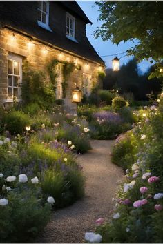 a house that is lit up with lights in the front yard and flowers on the side