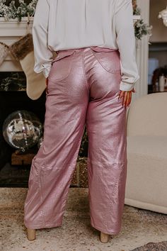 - Add a unique option to your closet with these trendy pants! - Unlined, stretchy metallic material - A waistline with belt loops, a hidden zip fly, and button closure - Three functional front pockets as well as back flap closure pockets - A wide legged silhouette that ends in straight floor length hemlines Pink High-waisted Pants With Belt Loops, Pink Bottoms With Elastic Waistband For Fall, Chic Pink Leather Pants, Spring Pink Leather Pants For Night Out, Pink Trousers For Night Out, Pink Leather Pants For Night Out In Spring, Pink Leather Pants For Spring Night Out, Chic Pink Leather Pants For Spring, Pink Long Pants For Night Out