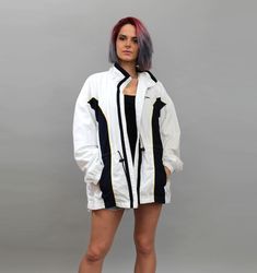 "Vintage lightweight white parka from 90s. This retro sports bomber style tracksuit jacket is made of polyester and cotton. The windbreaker has zipper closure and front pockets. Perfect for casual workout norm core wear as well as hip hop / rave / hipster style.  ▼ C O N D I T I O N: EXCELLENT vintage. No stains, tears or any other flaws. ▼ S I Z E: Labeled size L (Eur). To get sure if it FITS YOU, please take a look at the exact measurements below. ▼ M E A S U R E M E N T S (flat):  Length (fro Hooded White Nylon Windbreaker, 90s White Windbreaker For Sports, White Hooded Windbreaker With Reflective Details, White Parka, White Nylon Windbreaker With Double-lined Hood, Vintage Windbreaker Jacket, White Jacket Women, Nylon Windbreaker With Double-lined Hood For Sports, Spring Outerwear