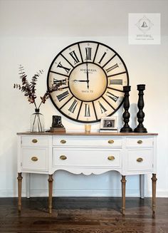 a large clock mounted to the side of a white dresser