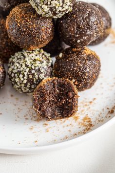 a white plate topped with chocolate truffles covered in powdered sugar and sprinkles