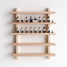 several wooden shelves with legos on them in the shape of people sitting and standing