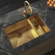 a kitchen sink with two gold faucets in it