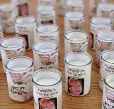 many candles with pictures on them sitting on a table