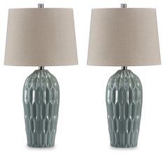 two blue vases with lamps on top of them, one has a beige shade