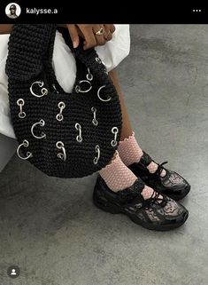 a woman's legs with black shoes and a handbag on the ground next to her