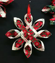 an ornament made out of dollar bills and ribbon is displayed on a black surface