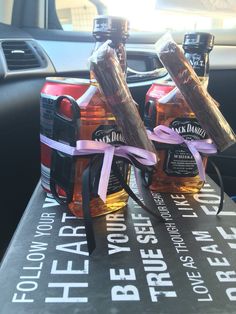 two bottles of alcohol sitting on top of a table in the back seat of a car