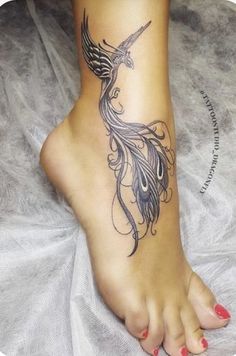 a woman's foot with a bird tattoo on it