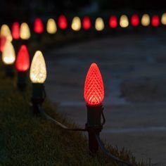 there are many red and white lights on the grass in front of each other, all lit up