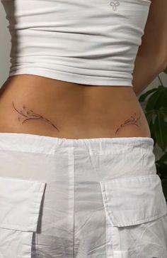 the back of a woman's stomach with tattoos on her lower body and bottom part