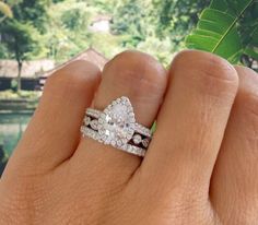 a woman's hand holding two wedding rings and a ring with diamonds on it