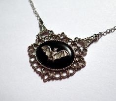 This lovely necklace features a silver bat mounted on a black base, which is framed and accented by antiqued silver plated filigrees.Centerpiece is 1 3/4" tall and 2" wideNecklace length is adjustable from 15-18"Matching earrings are available in our storeIf you have any questions, please feel free to let us know. Dark Accessories, Victorian Vampire, Vampire Bat, Gothic Victorian, Gothic Accessories, Choker Pendant, Cameo Necklace, Victorian Gothic, Lovely Necklace