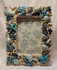 this is a photo frame made out of sea shells