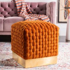 a living room area with a couch, chair and ottoman in orange velvete upholster