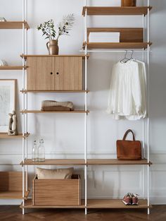 an open closet with wooden shelves and white walls