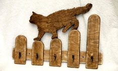 a dog jumping over a fence made out of wooden planks with nails stuck to it