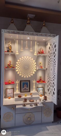 a display case with many items on it in a room that is white and has gold accents