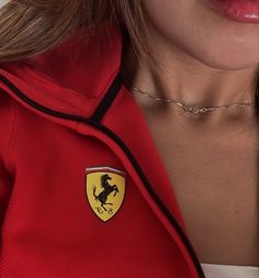 a woman wearing a red shirt with a ferrari logo on it