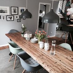 a wooden table topped with vases filled with tulips next to a staircase