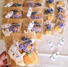 there are many decorated cookies in bags on the table with ghostes and pumpkins