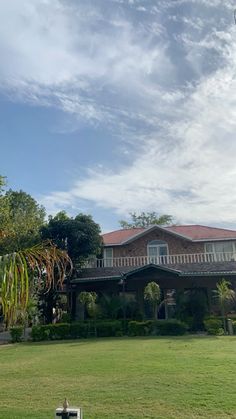 a large house sitting on top of a lush green field