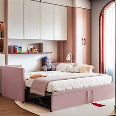 a child's bedroom with pink furniture and white cupboards on the wall, along with bookshelves