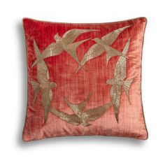 a red pillow with birds on it