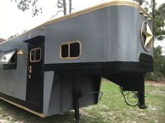 a black and gold trailer is parked in the grass