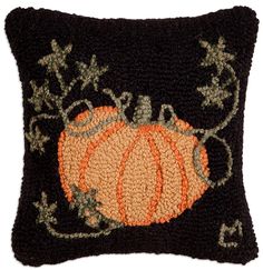 a black pillow with an orange pumpkin on it