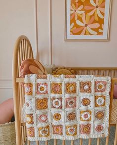 a crocheted baby blanket sitting on top of a wooden crib