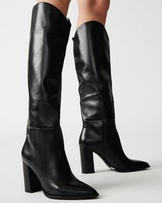 A pointed toe and curved topline give the BIXBY block heel knee boot a Western edge while the sleek upper highlights the clean monochrome look Point toe block heel knee boot Slip-on style Curved topline 3.5 inch heel height Size 6 measurements: 15.5 inch shaft circumference, 14.25 inch shaft height Size 8 measurements: 16 inch shaft circumference, 15 inch shaft height Size 10 measurements: 17 inch shaft circumference, 15.5 inch shaft height Leather upper material Synthetic and textile lining Syn Knee High Brown Leather Boots, Platform Slip Ons, Black Leather Knee High Boots, Ballet Bag, Steve Madden Store, Black Boots Tall, Knee Boot, Fashion Icons, Mary Jane Heels