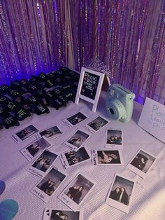 a table topped with pictures and photos next to a wall covered in purple sequins