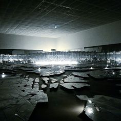 an empty room with many pieces of paper on the floor and lights in the ceiling