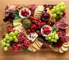 a platter filled with cheese, fruit and crackers