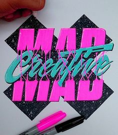 someone is writing on a piece of paper that has the words mad creative written in it