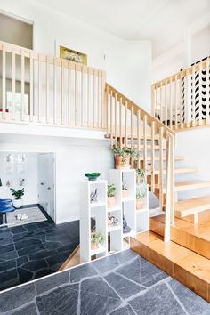 there is a staircase in the house with potted plants on shelves next to it