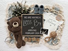 a baby announcement with teddy bear, booties, and other items on a blanket