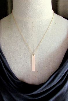 "This gold bar necklace is a long vertical gold filled rectangle pendant.  It is a brushed gold minimalist necklace.  Using a precisely cut gold filled (14K GF has a thick layer of 14 karat gold over a base...won't wear off, discolor like plated gold) bar (1.5\" x .25\"), I filed, sand and polish the piece after brushing the surface for a lovely shimmer.    Select from the drop-down box for your chain.  The choices are available in several lengths including 16\", 18\" or 20\" (on model), with a Minimalist Yellow Gold Bar Necklace With Rectangular Pendant, Yellow Gold Rectangular Bar Necklace, Gold Rectangular Bar Necklace, Gold Minimalist Rectangular Bar Necklace, Gold Rectangular Minimalist Bar Necklace, Minimalist Gold Rectangular Bar Necklace, Minimalist Rose Gold Necklace With Rectangular Pendant, Gold Bar Necklace With Rectangular Pendant For Everyday, Modern Gold Bar Necklace With Rectangular Pendant