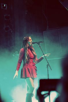 a woman standing on top of a stage holding a microphone