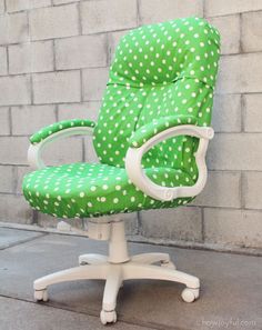 a green office chair sitting in front of a brick wall