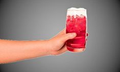 a hand holding a glass filled with liquid