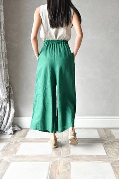 "ELISE wide linen pants are made from 100% pure linen, making them breathable, lightweight, and perfect for warm summer days. The loose cut and relaxed fit ensure maximum comfort. These palazzo linen pants have 2 deep functional side pockets that provide a convenient place to store your phone or some small items, while the elastic waistband allows for an adjustable and comfortable fit. Each piece in our linen shop is handcrafted with care, ensuring a unique and personal touch. The beautiful and Linen Wide-leg Harem Pants With Pockets, Linen Harem Pants With Pockets, Wide Leg Ramie Bottoms With Pockets, Green Linen Harem Pants With Elastic Waistband, Linen Bottoms With Elastic Waistband In Flax Color, Flax Linen Bottoms With Elastic Waistband, Green Linen Wide Leg Bottoms, Linen Trousers With Relaxed Fit, Casual Green Linen Bottoms