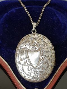 "Gorgeous sterling silver Antique Victorian Aesthetic (circa 1880's, no hallmarks, common in this era, however tested as silver)  ornately engraved double sided locket finely detailed with vacant cartouche in the shape of a shield surrounded by flowers and ivy leaves with decorative border.  To the other side, is a \"greek key meander\" design signifying \"eternity\" again surrounded by decorative ivy leaves and scrolls.  A beautiful piece that looks like it was originally gilded (gold on silver) as it has very slight traces of this which is seen in the photos and can also be worn either way be worn either way around as a new (more modern sterling silver clip loop bail)  allows the owner to choose to change it around to which is side preferred. Opens at the side and closes well to reveal t Antique White Gold Necklace With Intricate Design, Antique White Gold Necklace, Victorian White Gold Medallion Necklace, Antique Silver Sterling Silver Vintage Locket Necklace, Antique Silver Hallmarked Necklace, Antique Hallmarked Silver Necklace, Antique Silver Necklaces With Intricate Design, Antique White Gold Necklaces With Locket, Ornate Antique Silver Oval Necklace