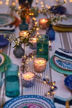 the table is set with candles and plates