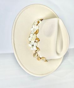 This is one of a kind ivory fedora  with a velvet trim detail and beautiful flower, pearl and gold petal applicate.  Making this item such a unique and rare item.  Perfect for any fancy occasion or to dress up an outfit.   All of my work is original and one of a kind. All rights are reserved to she is blooming.   Ivory velvet trim ONE SIZE   Wide brim  Vegan hat Can be adjusted to make smaller    She is blooming does not accept returns, exchanges or cancellations. Due to lighting  Color can appear  slightly different. Luxury Cream Fedora For Formal Occasions, Elegant White Adjustable Fedora, Handmade White Wedding Costume Hats And Headpieces, Elegant Cream Fedora Felt Hat, White Handmade Wedding Costume Hats And Headpieces, Handmade White Wedding Headpieces, Elegant White Fedora, Bohemian Adjustable Fascinator For Weddings, Elegant White Handmade Mini Hat